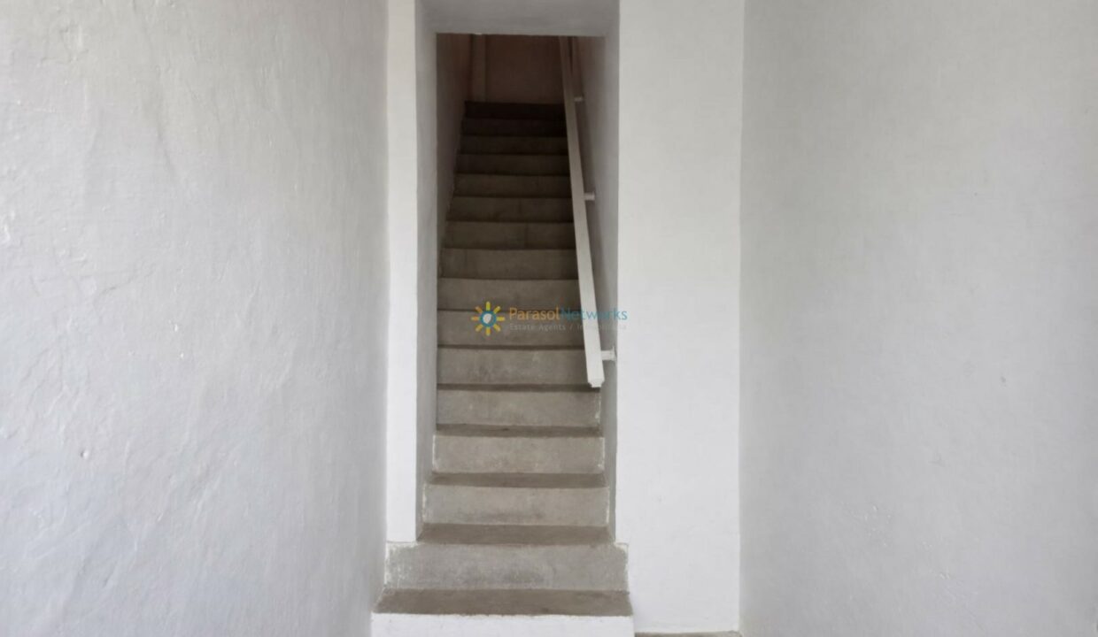 Pasillo minimalista con escalera de concreto