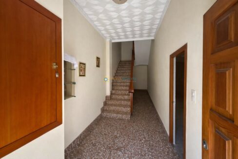 Pasillo residencial con escaleras y detalles vintage