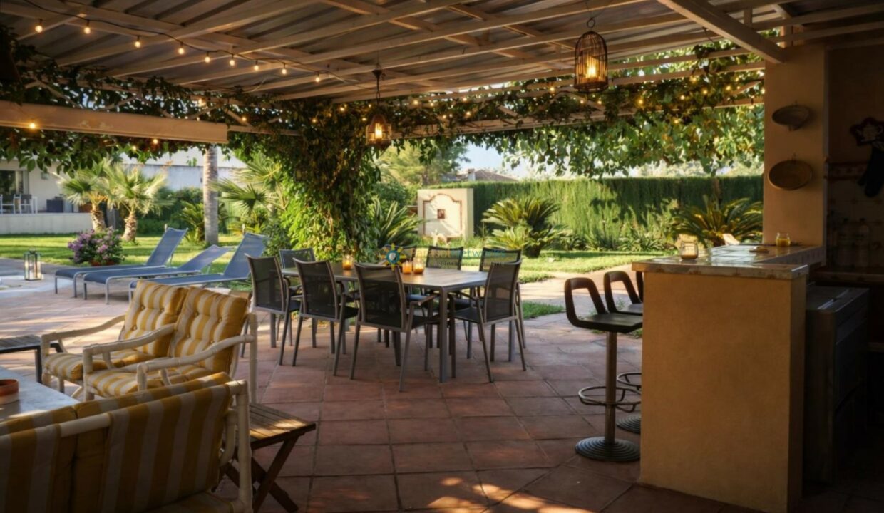 Patio con jardín y pergola decorada