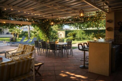 Patio con jardín y pergola decorada