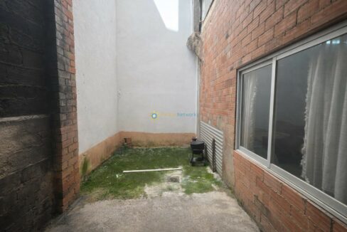 Patio estrecho con paredes envejecidas