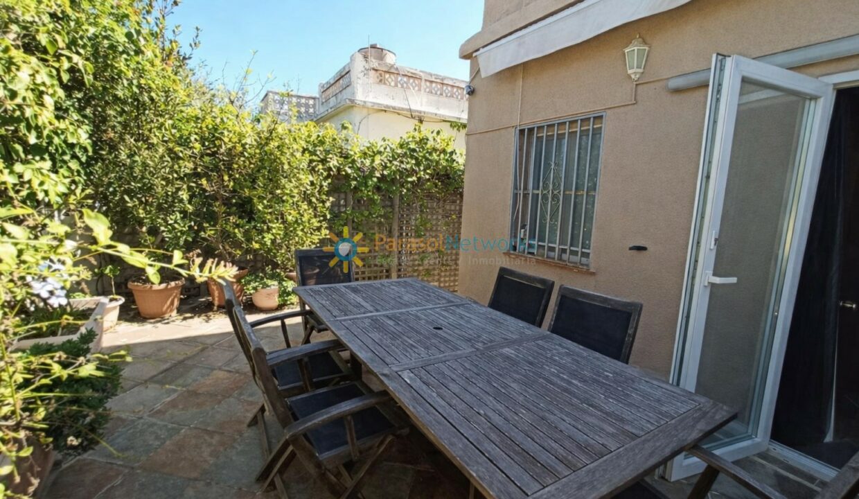 Patio soleado con mesa rústica