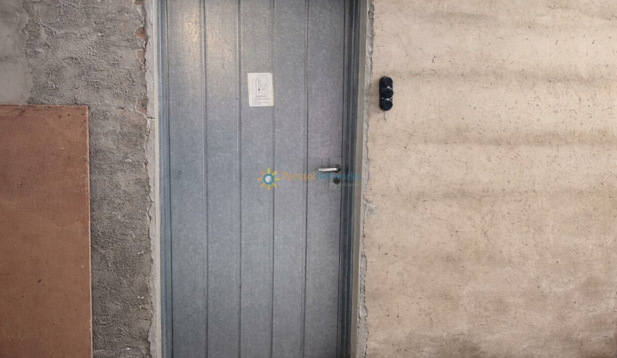 Puerta metálica en habitación sin terminar