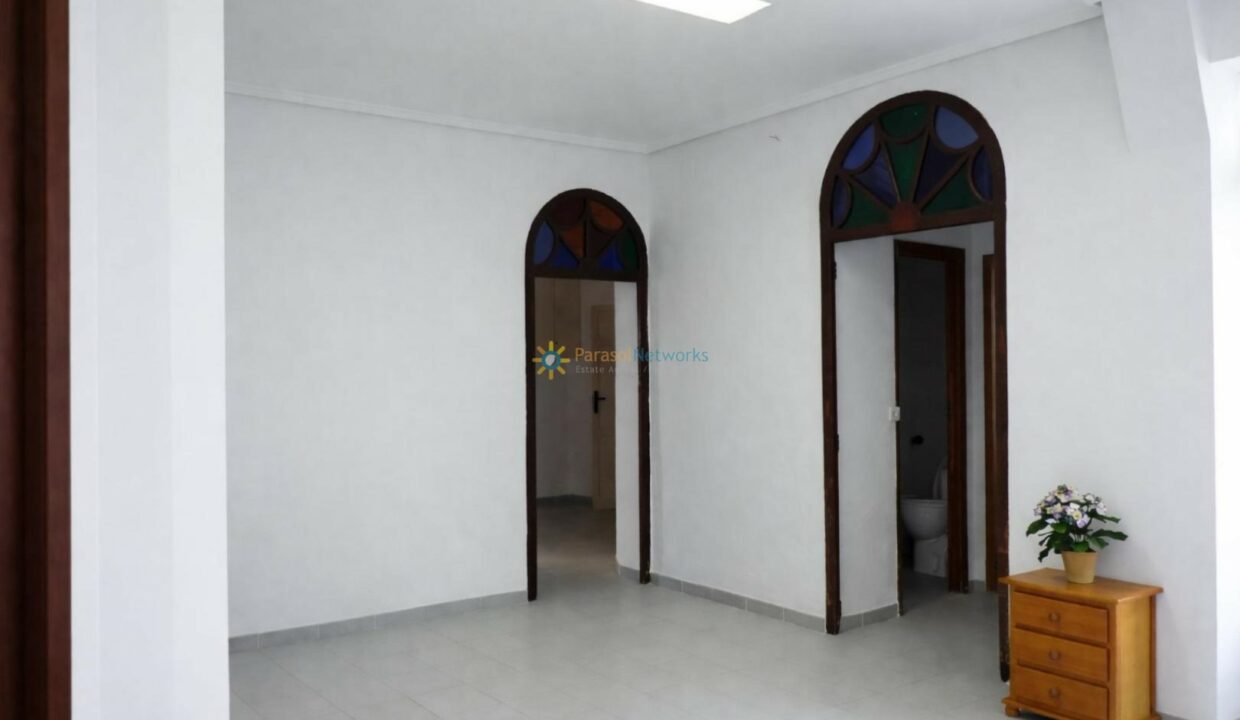 Sala espaciosa con puertas arqueadas de cristal vitral