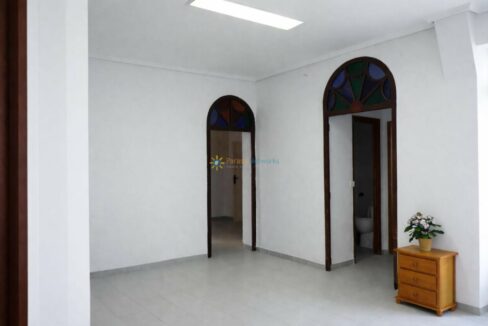 Sala espaciosa con puertas arqueadas de cristal vitral