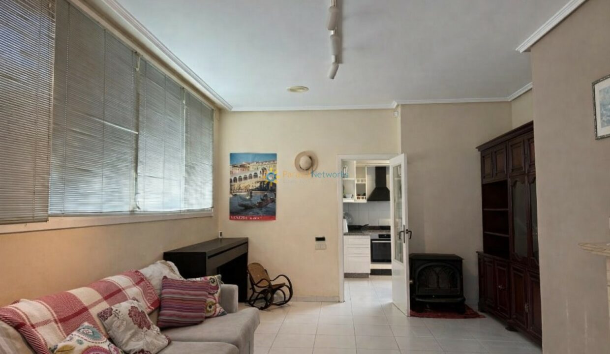 Sala luminosa con piano y estantería