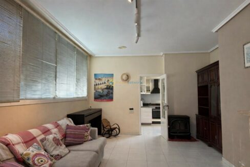 Sala luminosa con piano y estantería