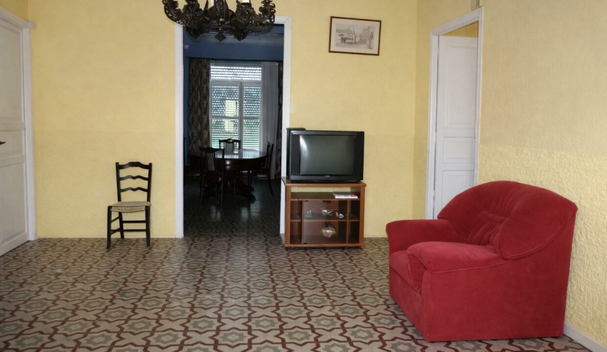 Sala luminosa con sillas y televisión