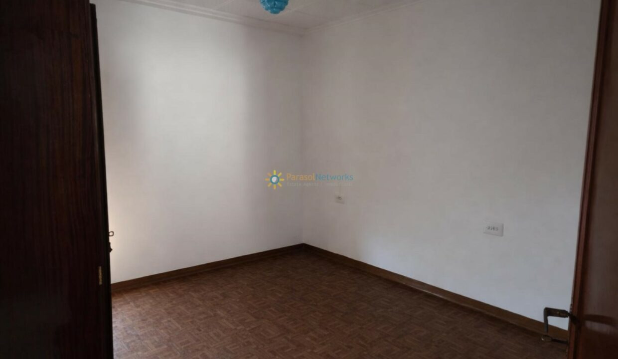 Sala vacía con paredes blancas y parquet