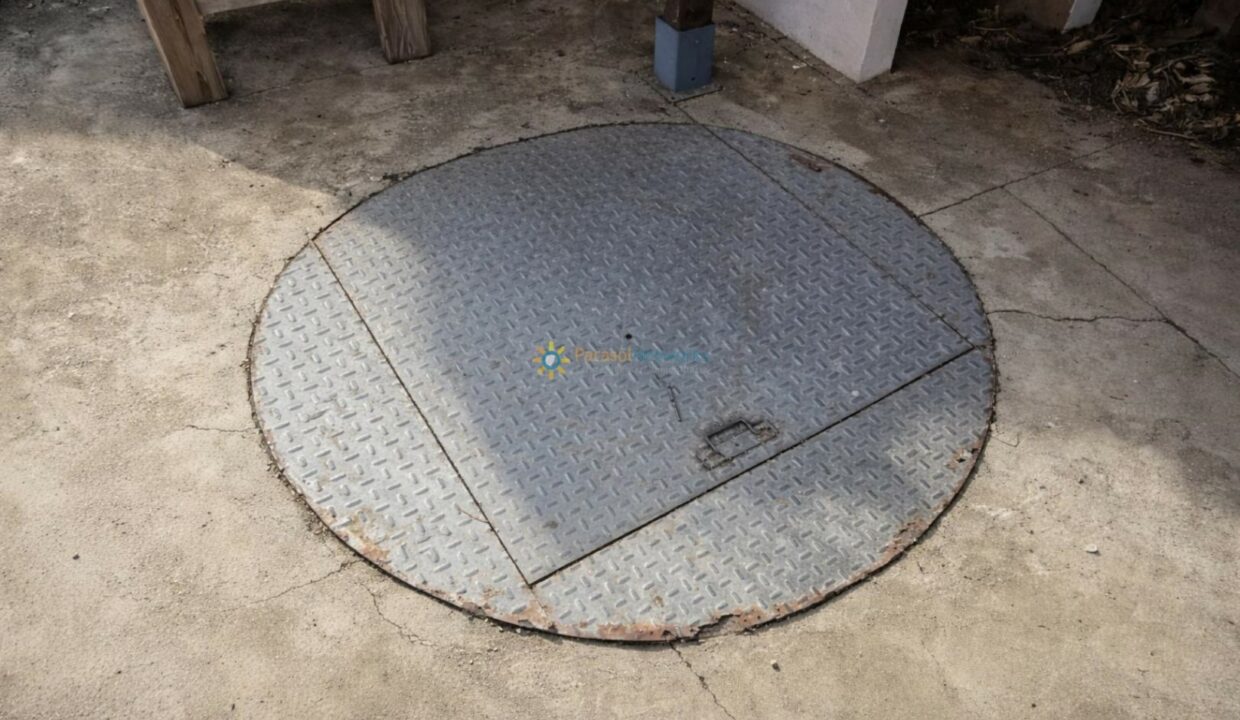 Tapa metálica oxidada en el suelo