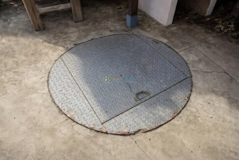 Tapa metálica oxidada en el suelo