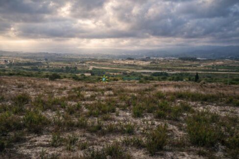 Valle agrícola bajo cielo nublado
