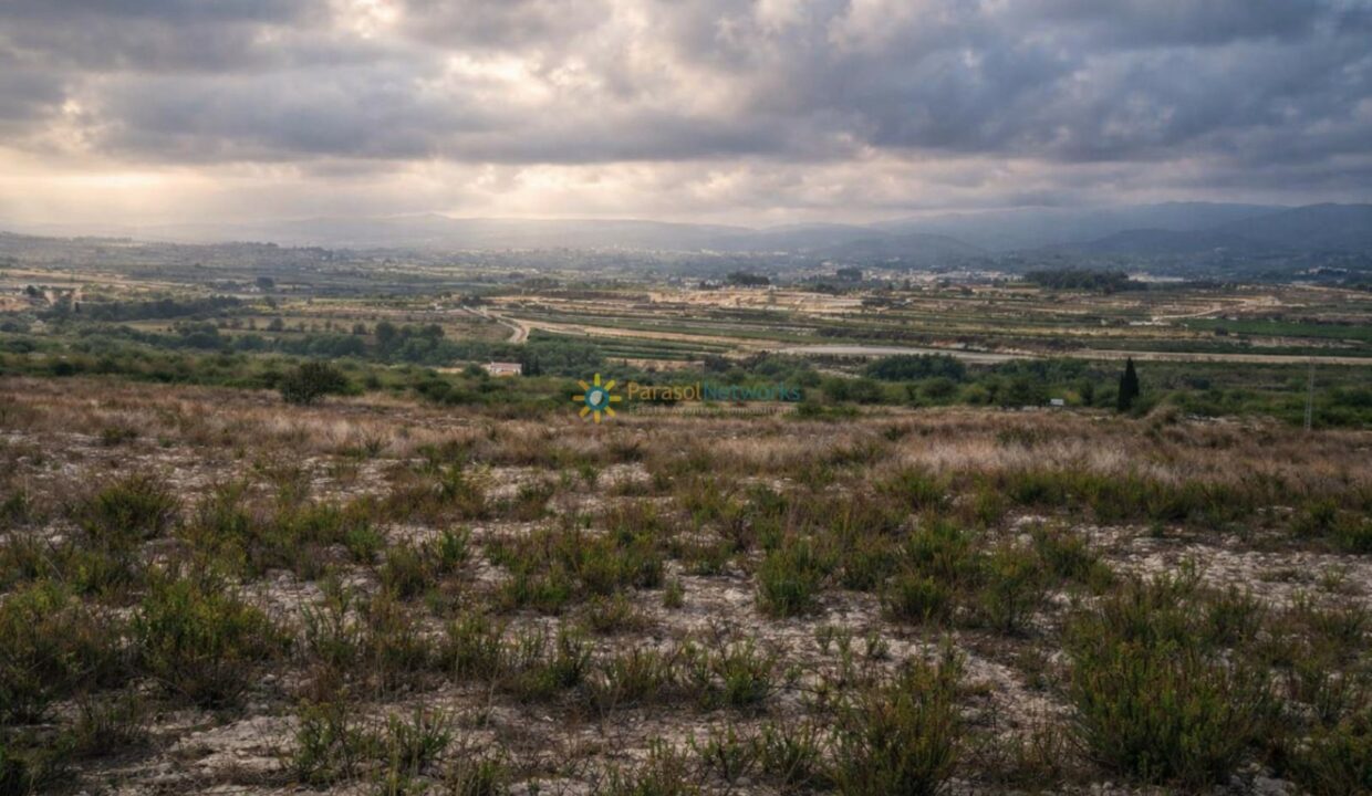 Valle agrícola bajo cielo nublado